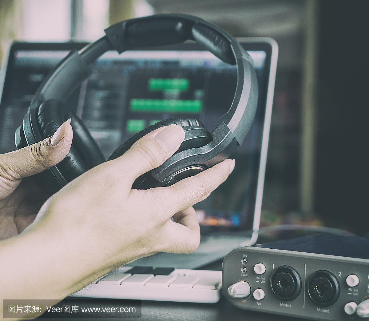 在錄音室工作的錄音師戴著耳機(jī)。