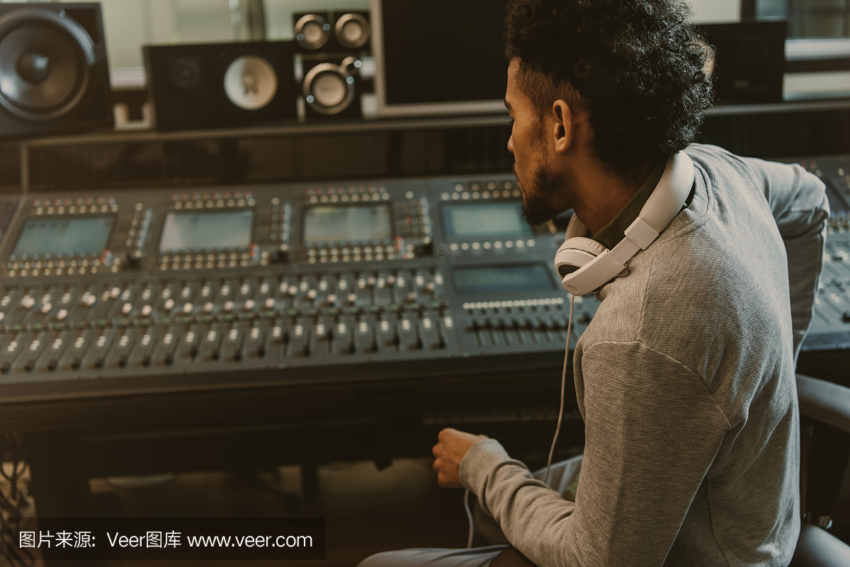 聲音制作人坐在扶手椅上,看著圖形均衡器